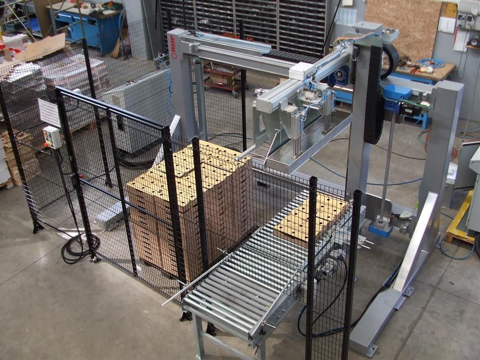 Una macchina sposta un pallet di scatole su un nastro trasportatore.