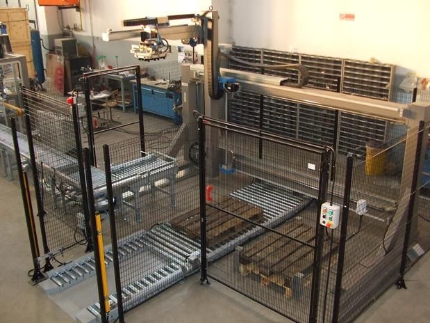 Una macchina sposta i pallet attraverso un'area recintata.