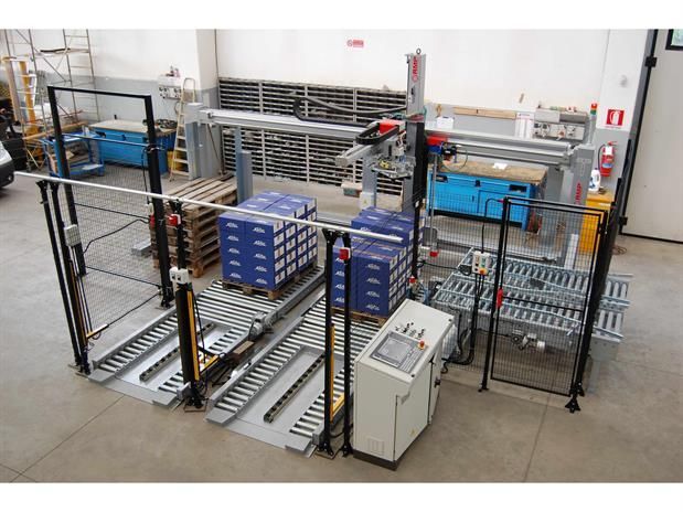 Una macchina sposta delle scatole su un nastro trasportatore in una fabbrica.