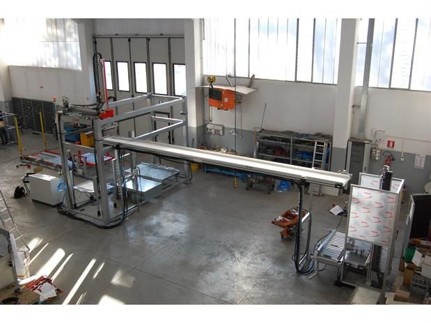 Una vista aerea di una fabbrica attraversata da un nastro trasportatore.