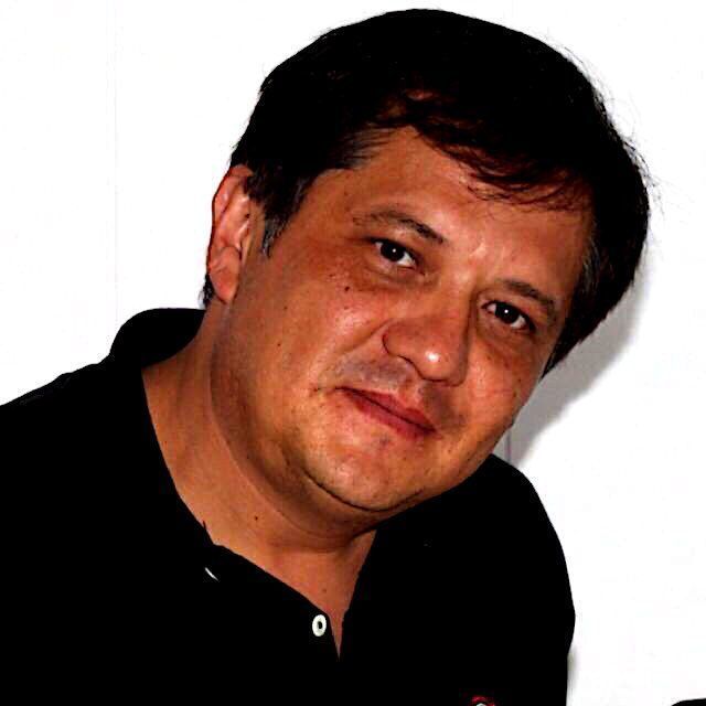 Un hombre con una camisa negra está mirando a la cámara.