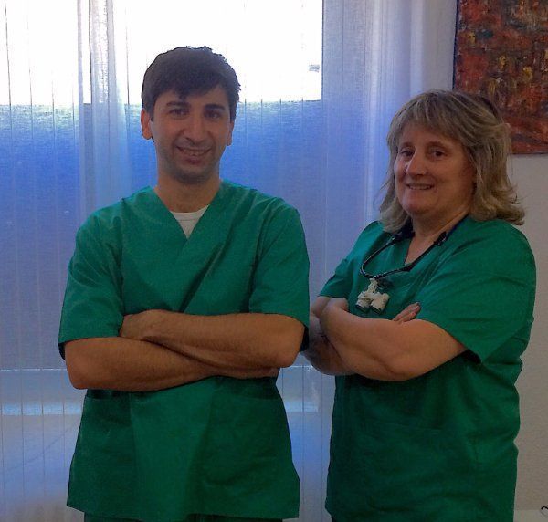 Un hombre y una mujer con uniformes verdes posan para una fotografía.