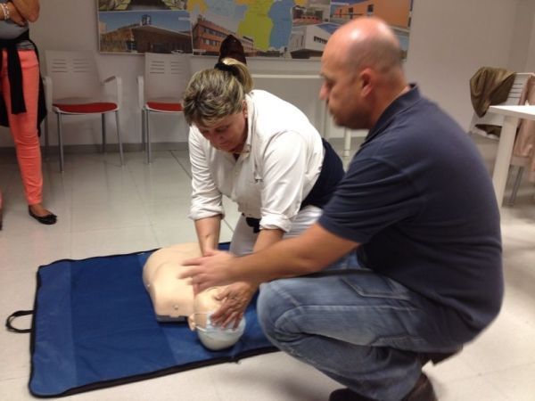 Un hombre y una mujer están practicando con un maniquí.