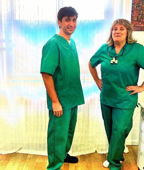 Un hombre y una mujer con uniformes verdes de pie uno al lado del otro