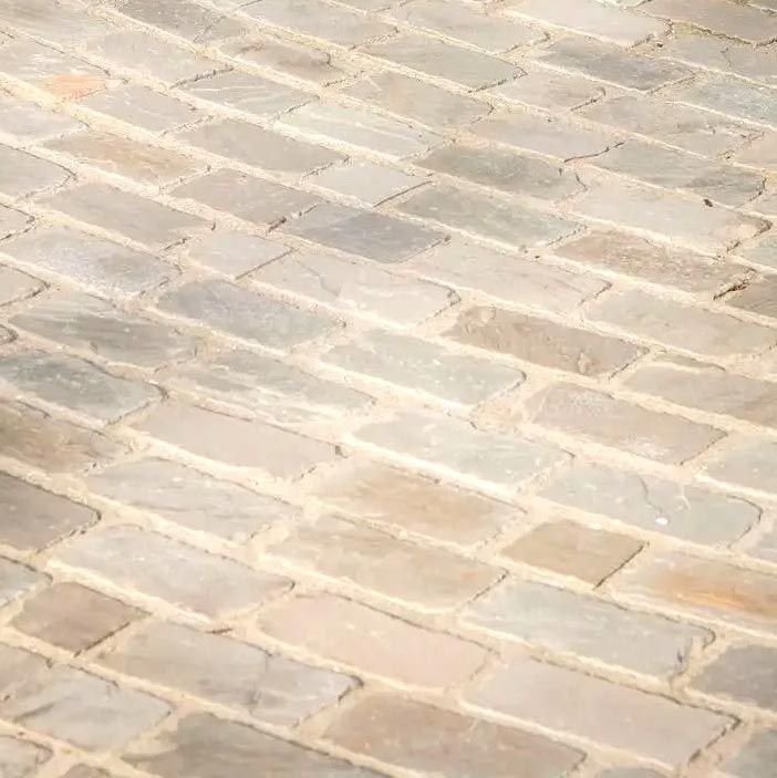 Chemin en briques avec différentes nuances de gris et de beige.