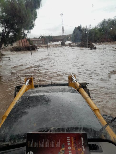 Un coche circula por una zona inundada con un libro en el parabrisas.