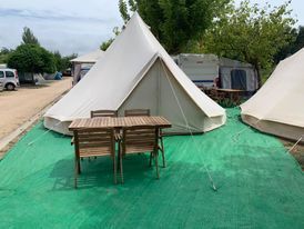 Una tienda de campaña con una mesa y sillas delante de ella.
