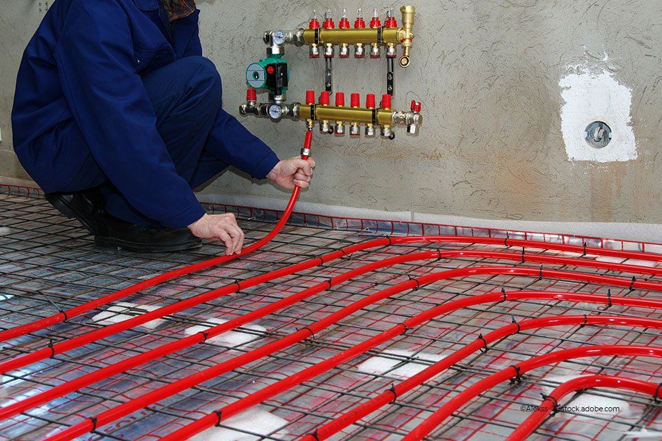 Mitarbeiter der Kröger Heizungs- und Sanitärtechnik GmbH installiert Fußbodenheizung