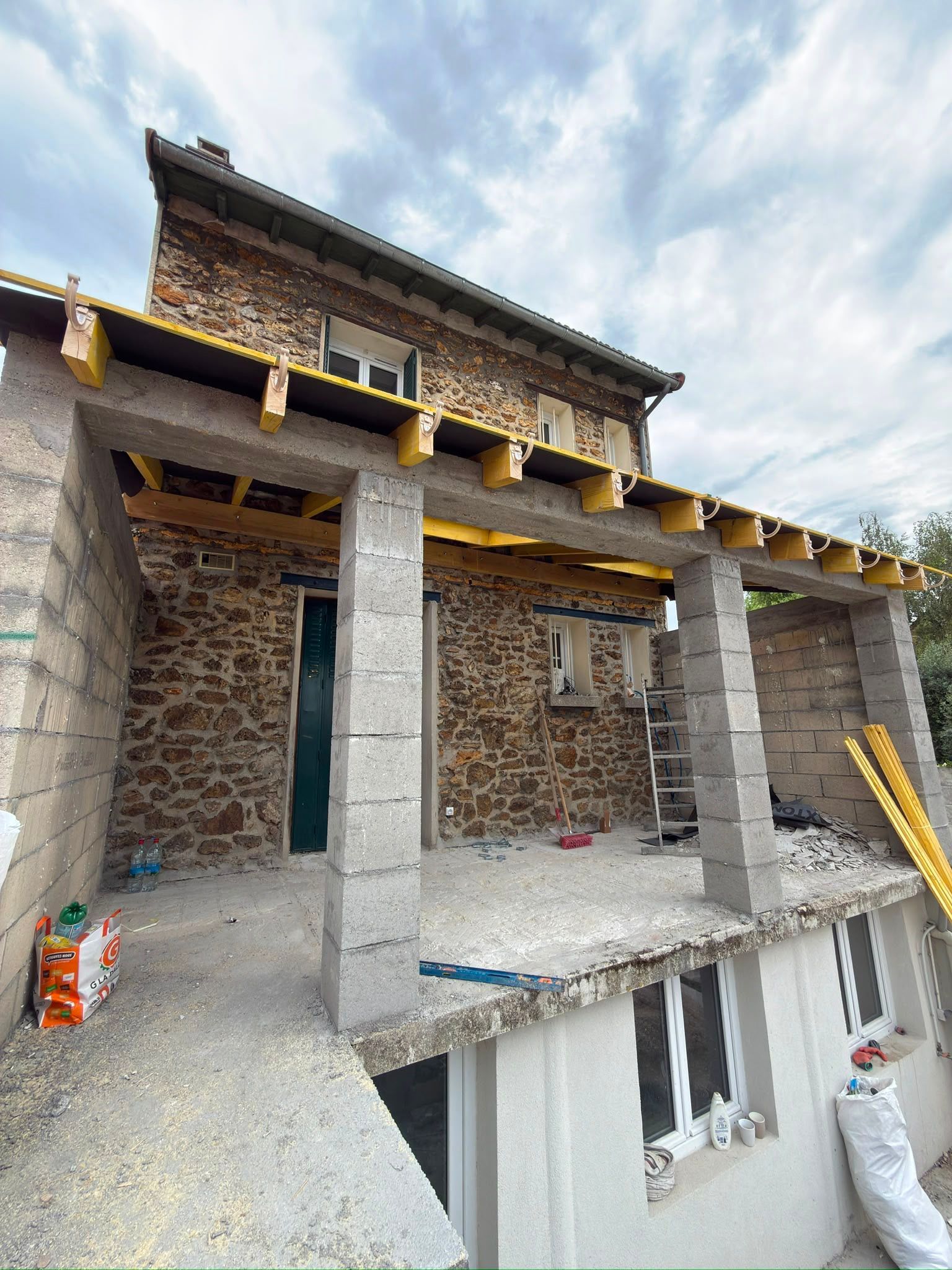Extension en construction avec des piliers en béton.