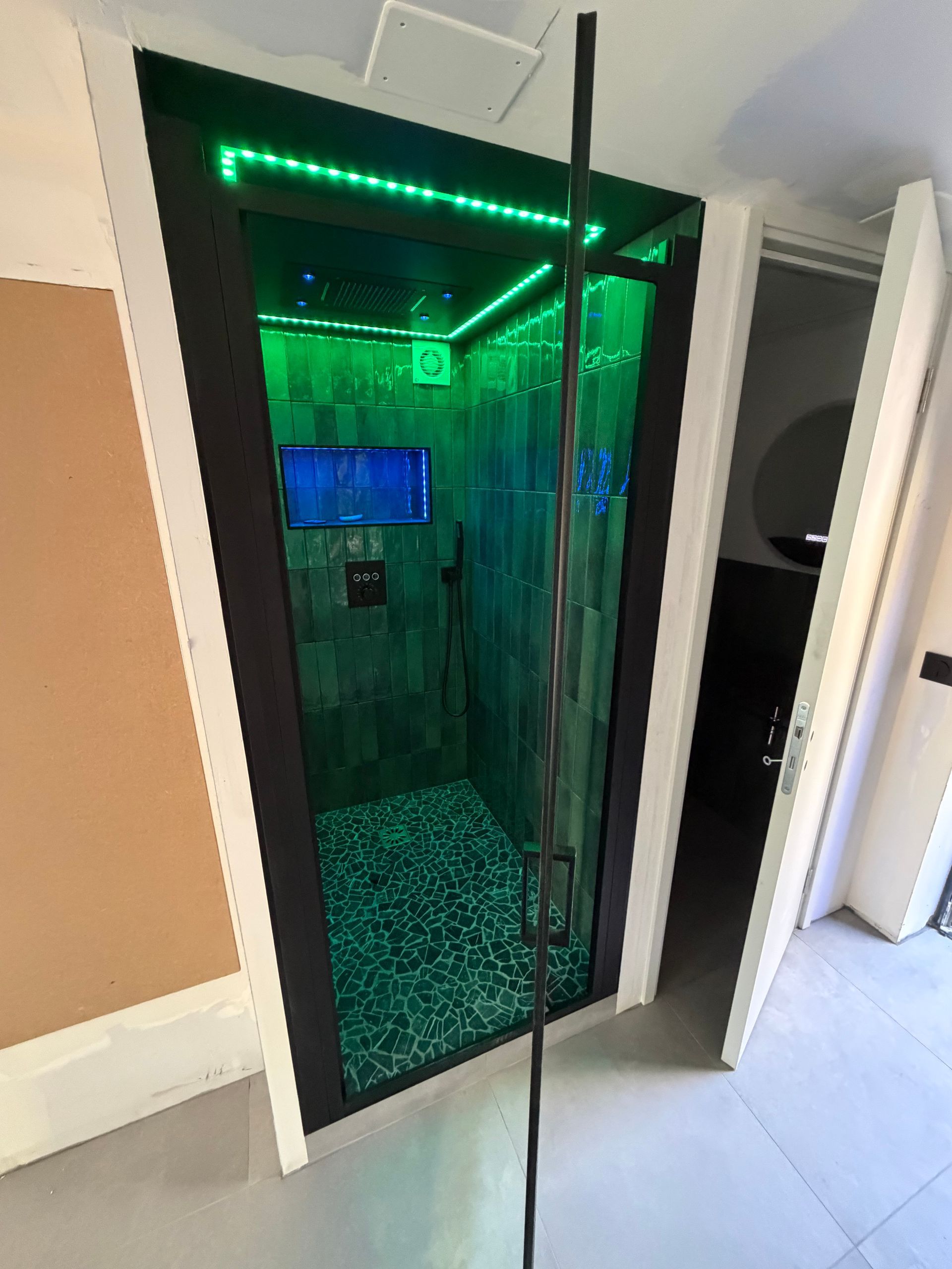 Une cabine de douche avec une porte vitrée.