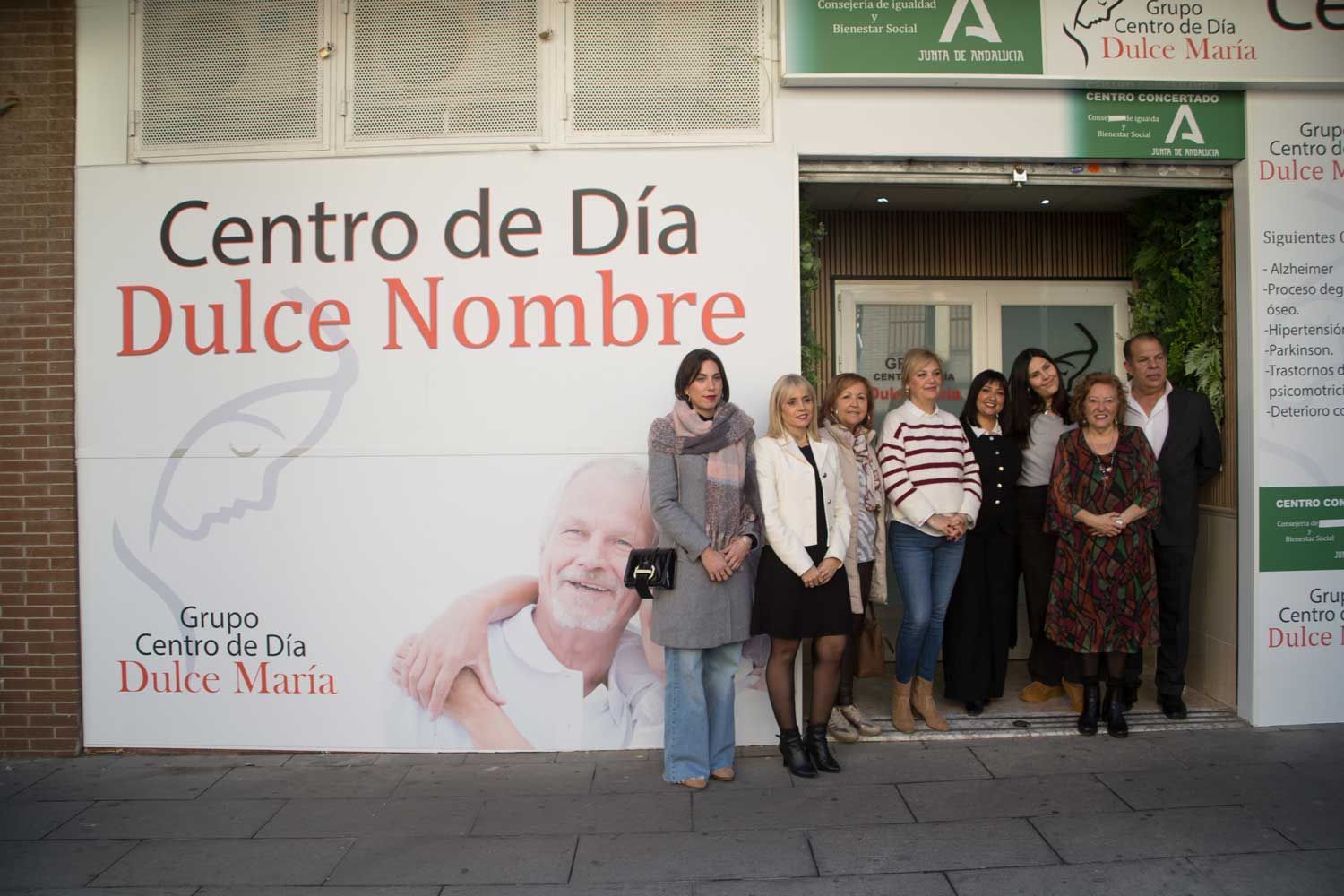 Un grupo de personas de pie frente a un cartel que dice centro de día dulce nombre