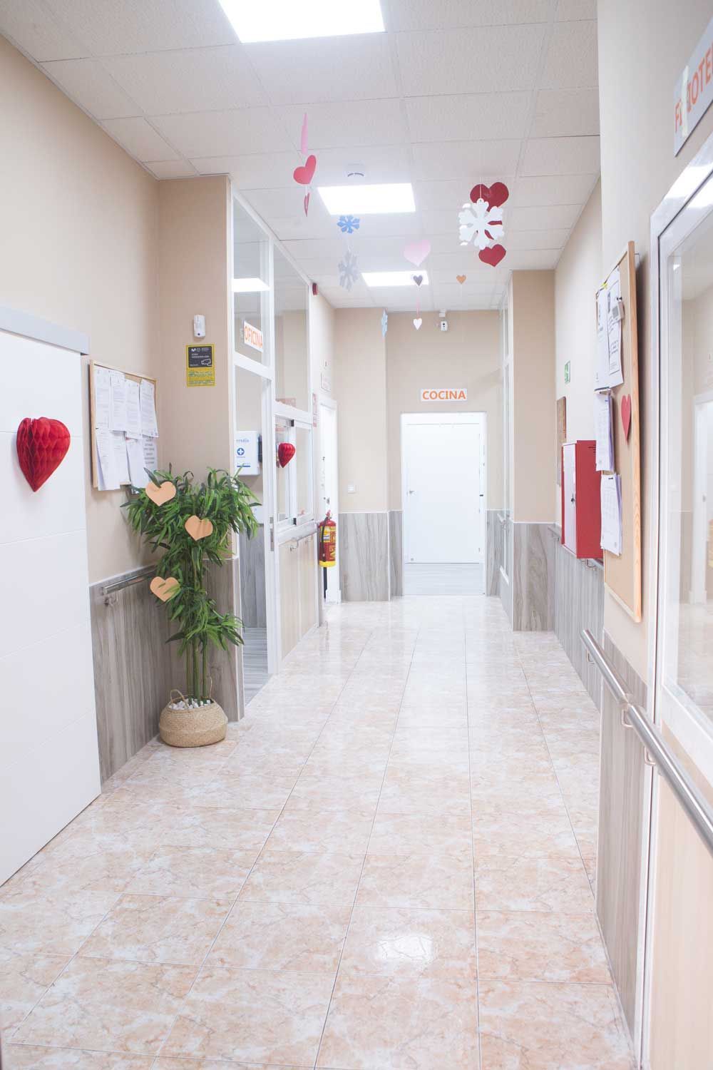 Un largo pasillo en un hospital con corazones colgando del techo.