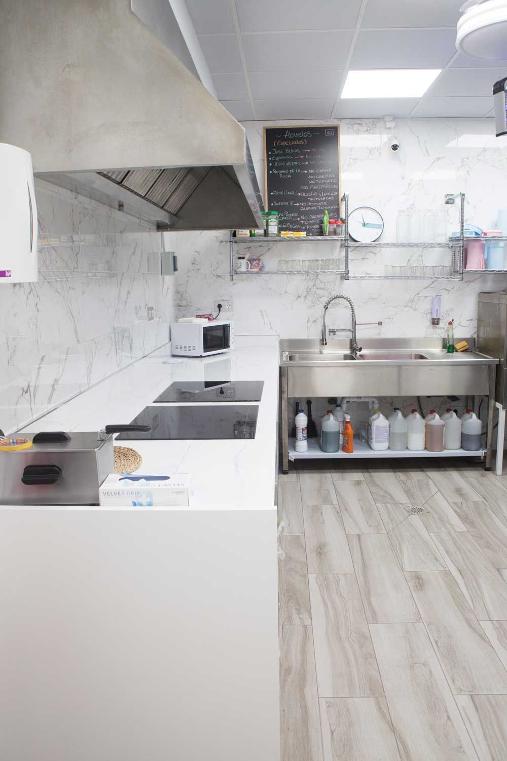 Una cocina con electrodomésticos de acero inoxidable, un fregadero y una estufa.