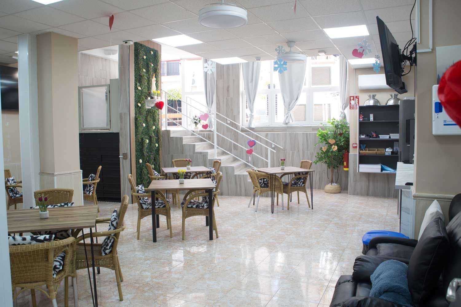 Una sala grande con mesas y sillas y un televisor.