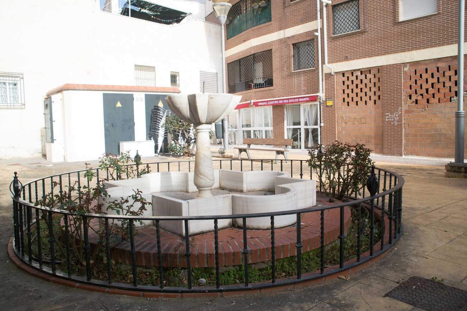 Una fuente en un patio con una valla alrededor.