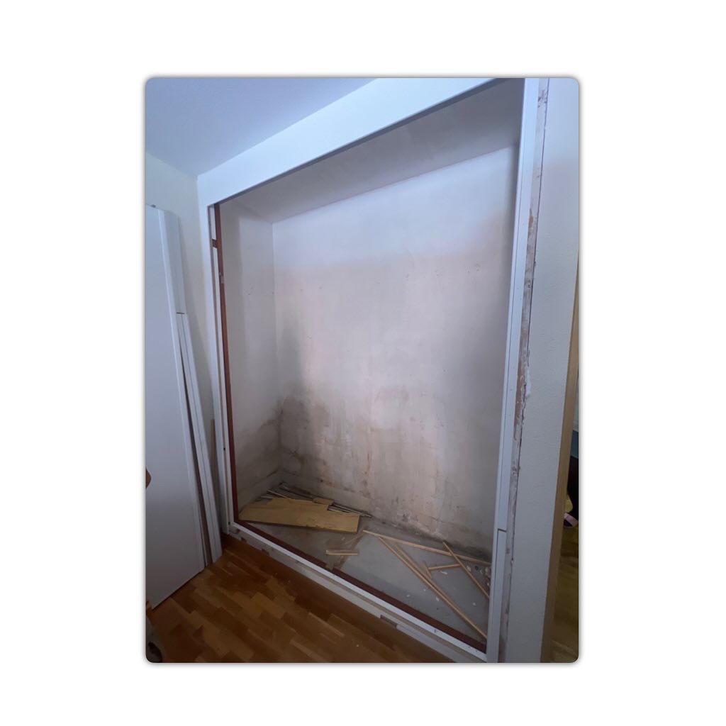 Una habitación con una ventana grande y una puerta.