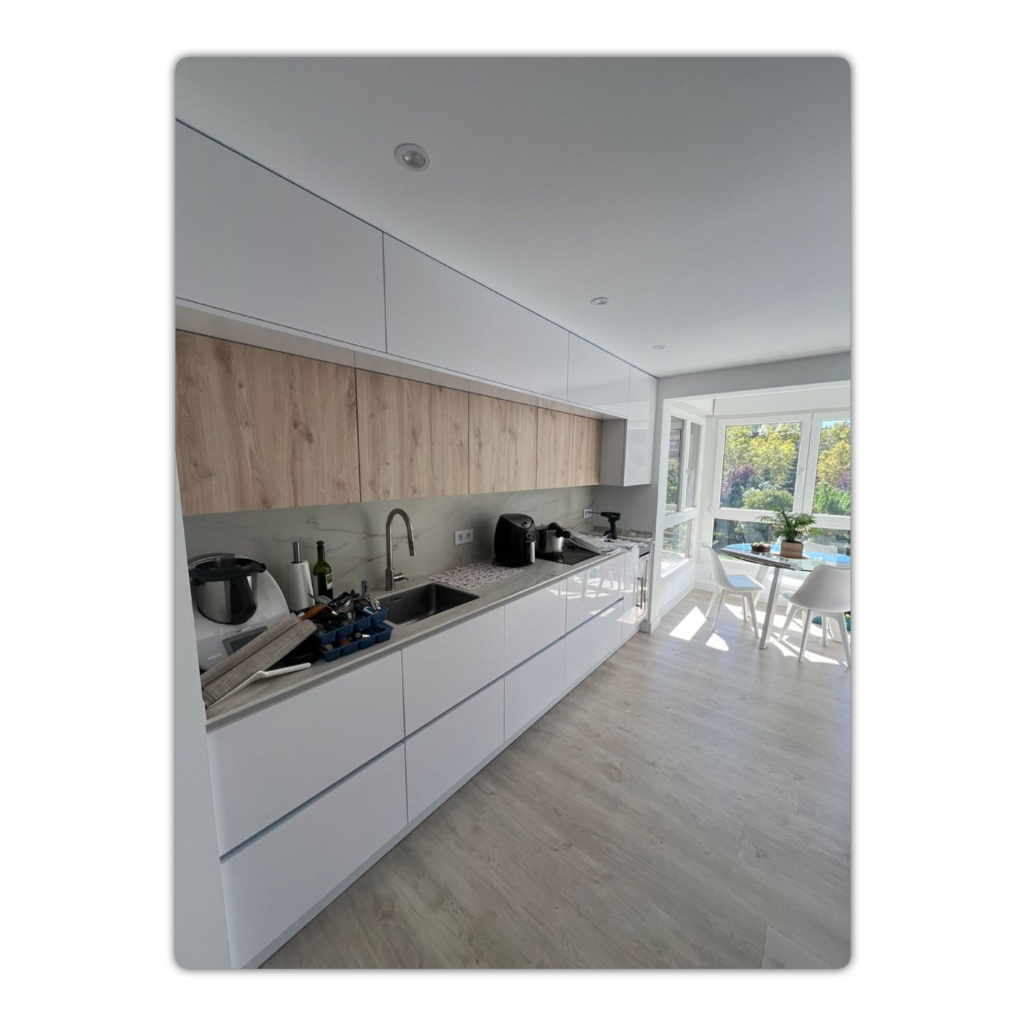 Una cocina con gabinetes blancos y encimeras de madera.