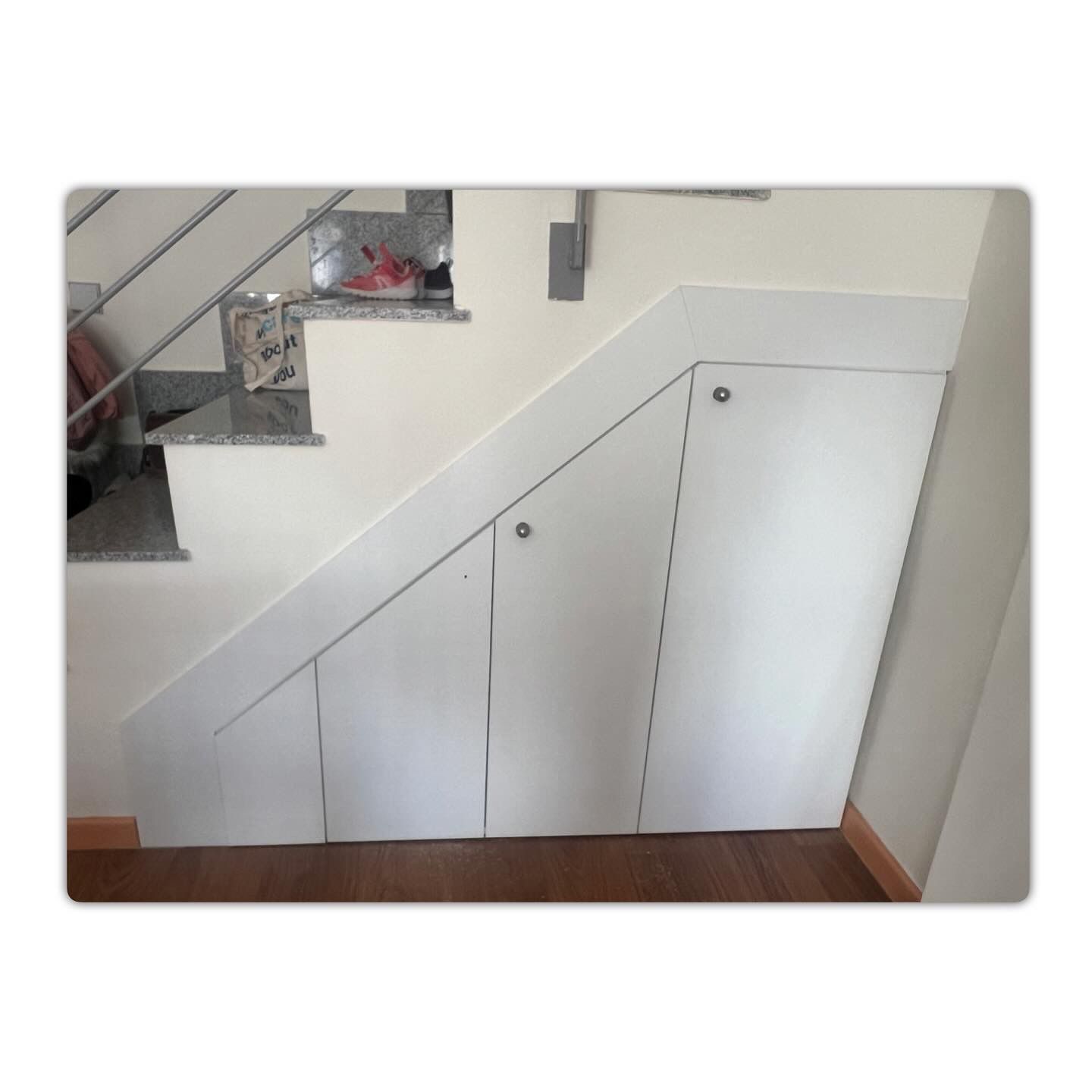 Una escalera con un armario blanco debajo.