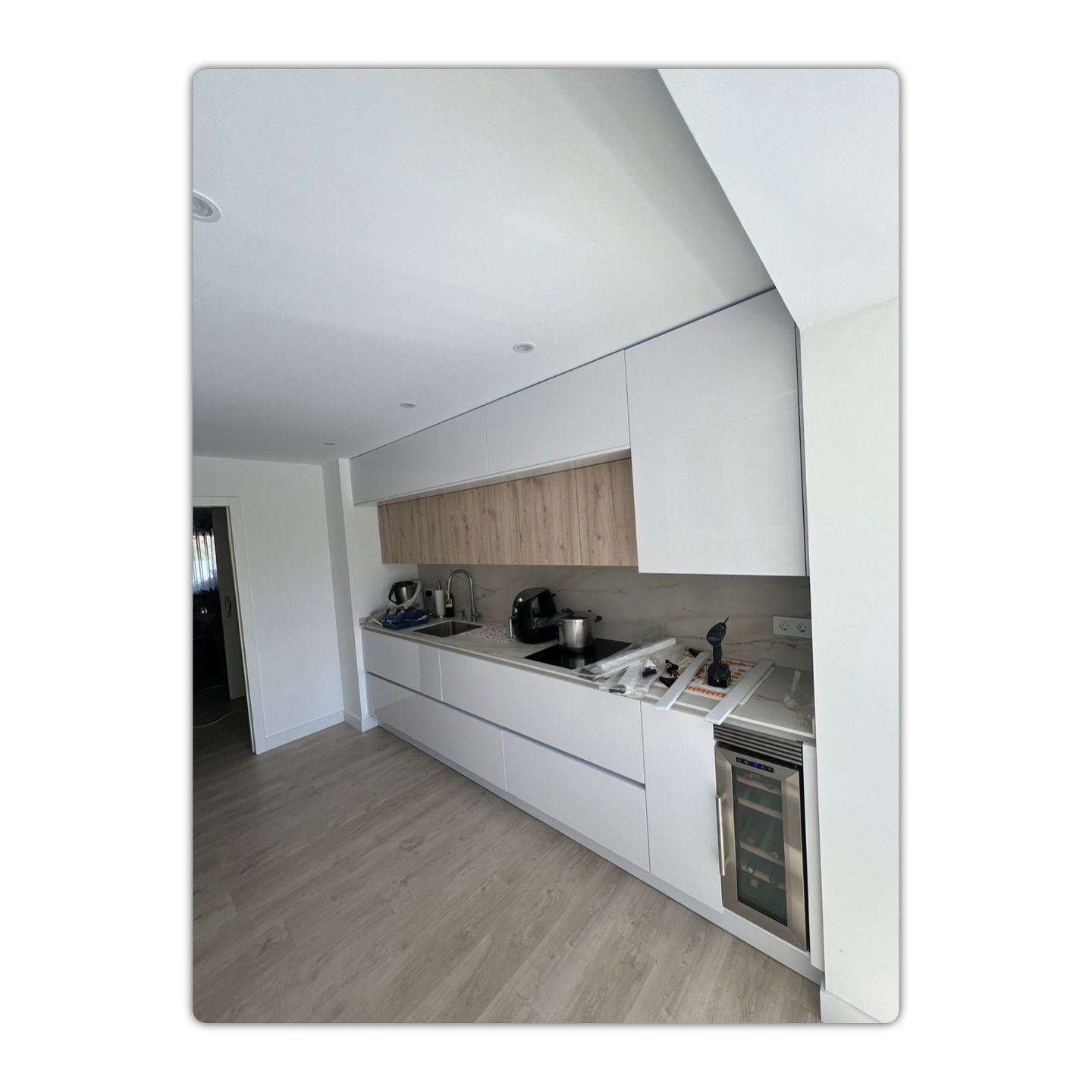 Una cocina con gabinetes blancos y encimeras de madera.