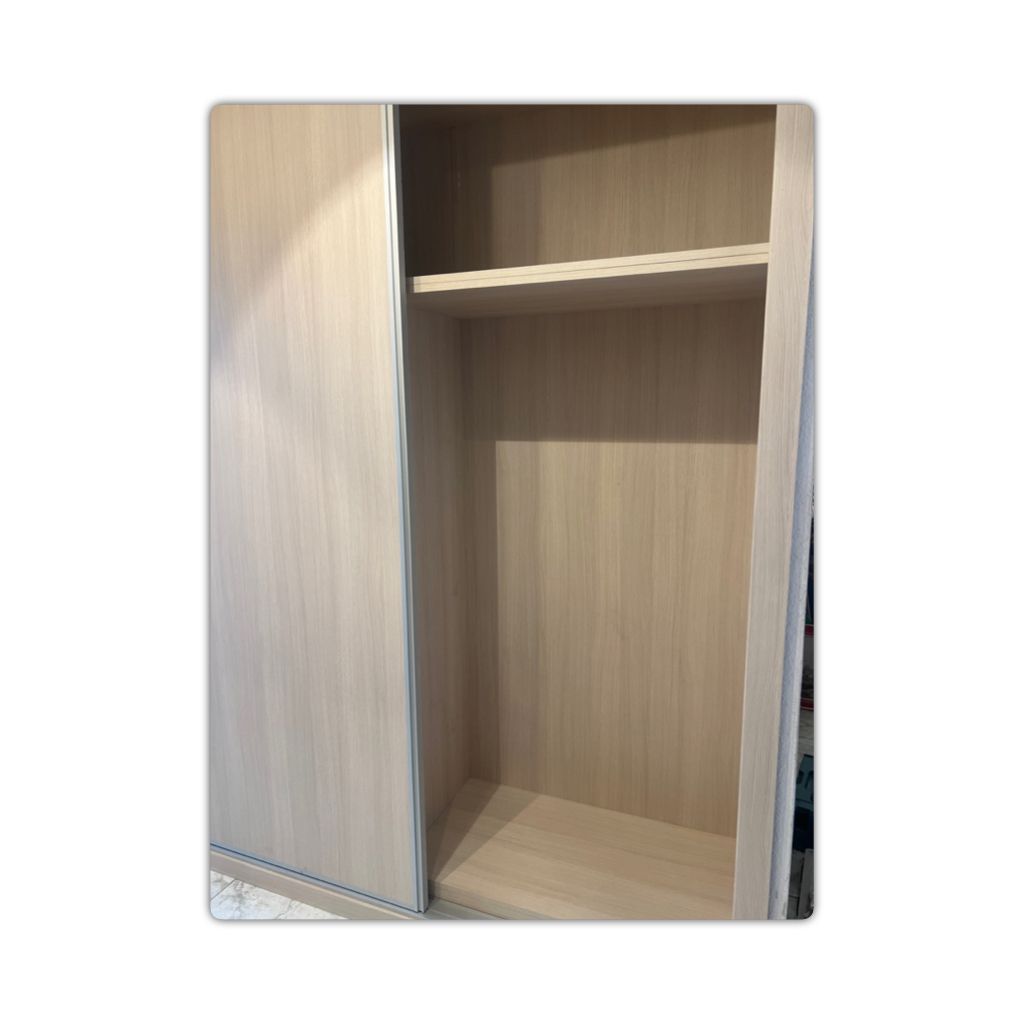 Un armario vacío con puertas corredizas y estantes.