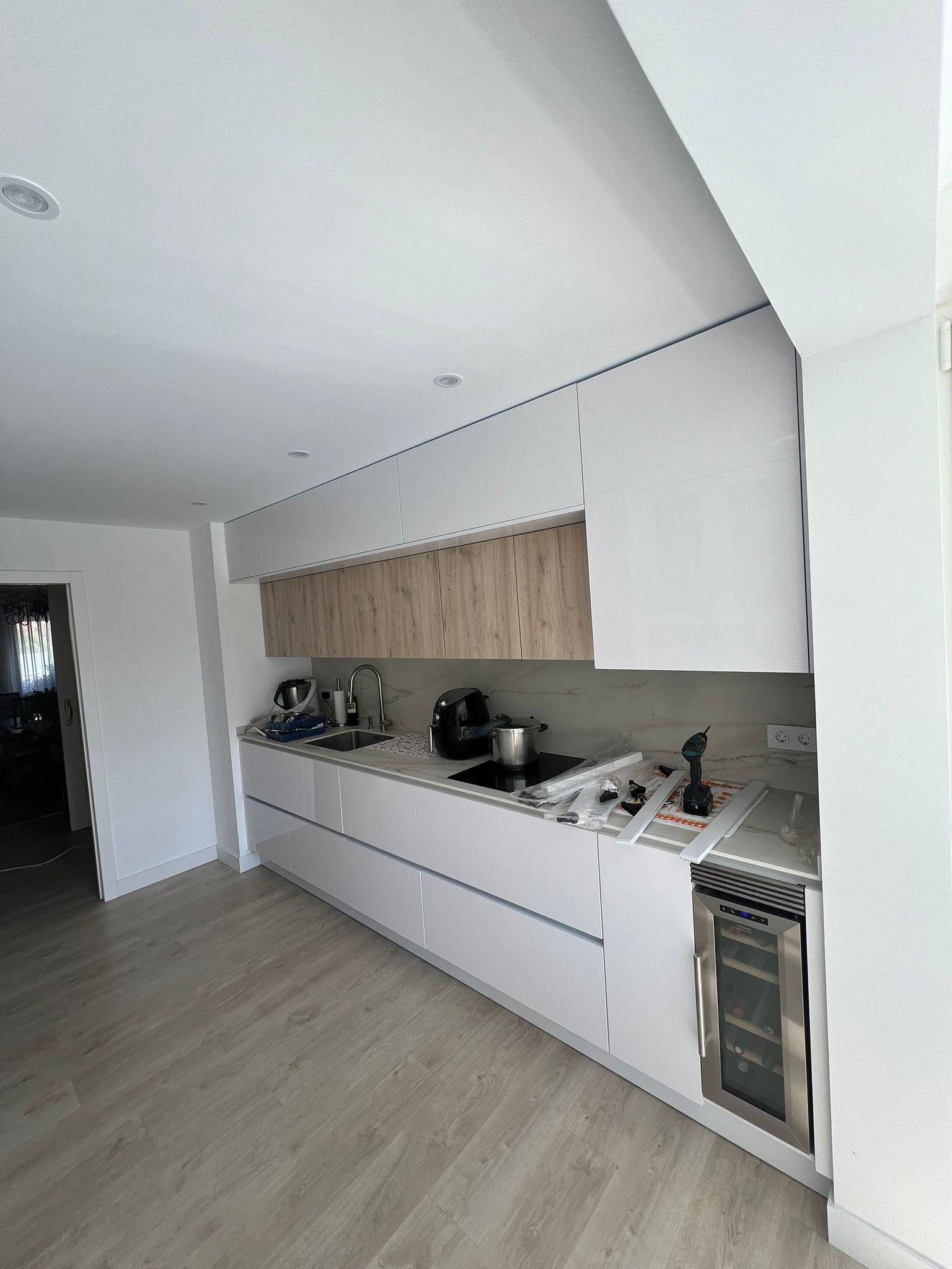 Una cocina con gabinetes blancos y encimeras de madera.