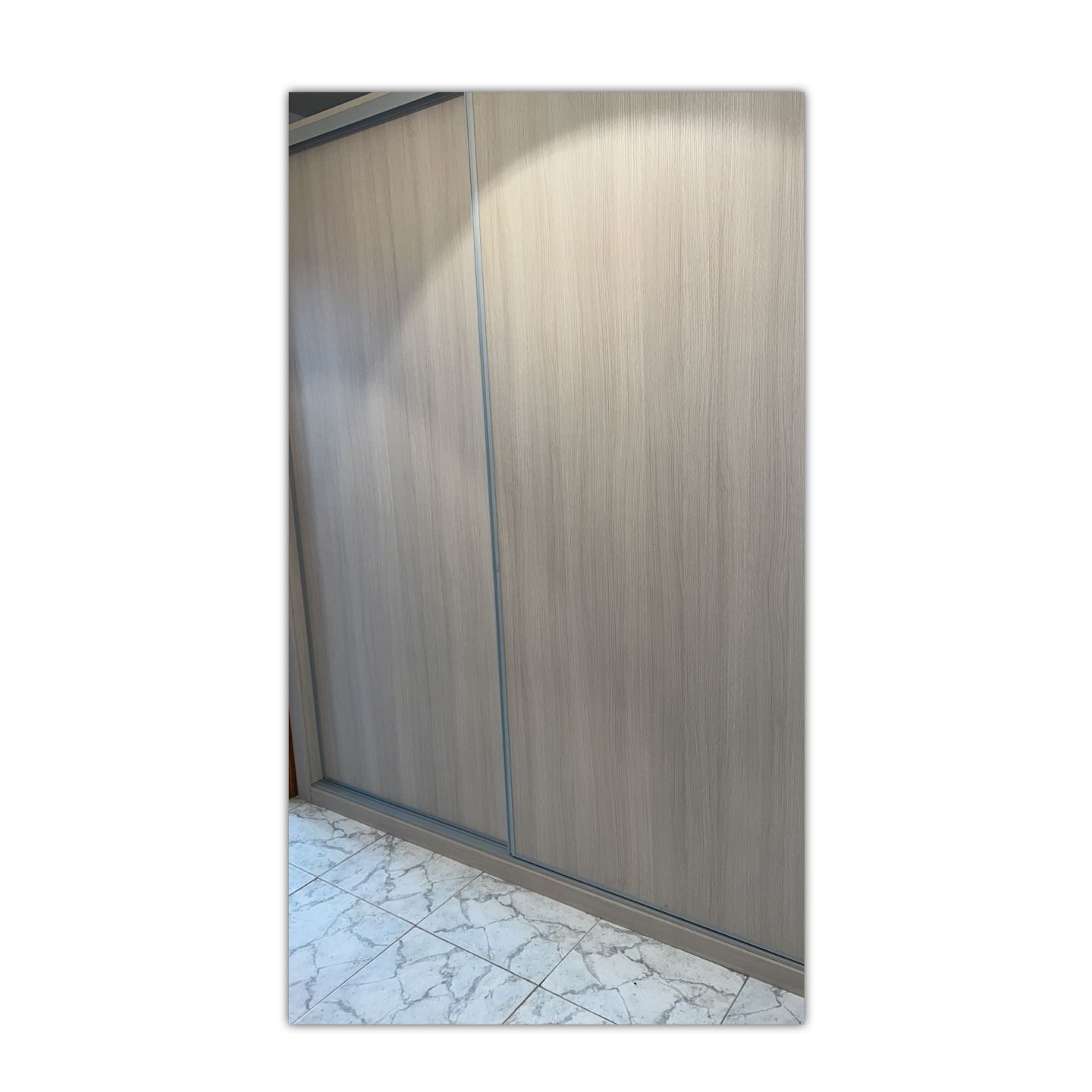 Una imagen de un armario con puertas correderas en una habitación.