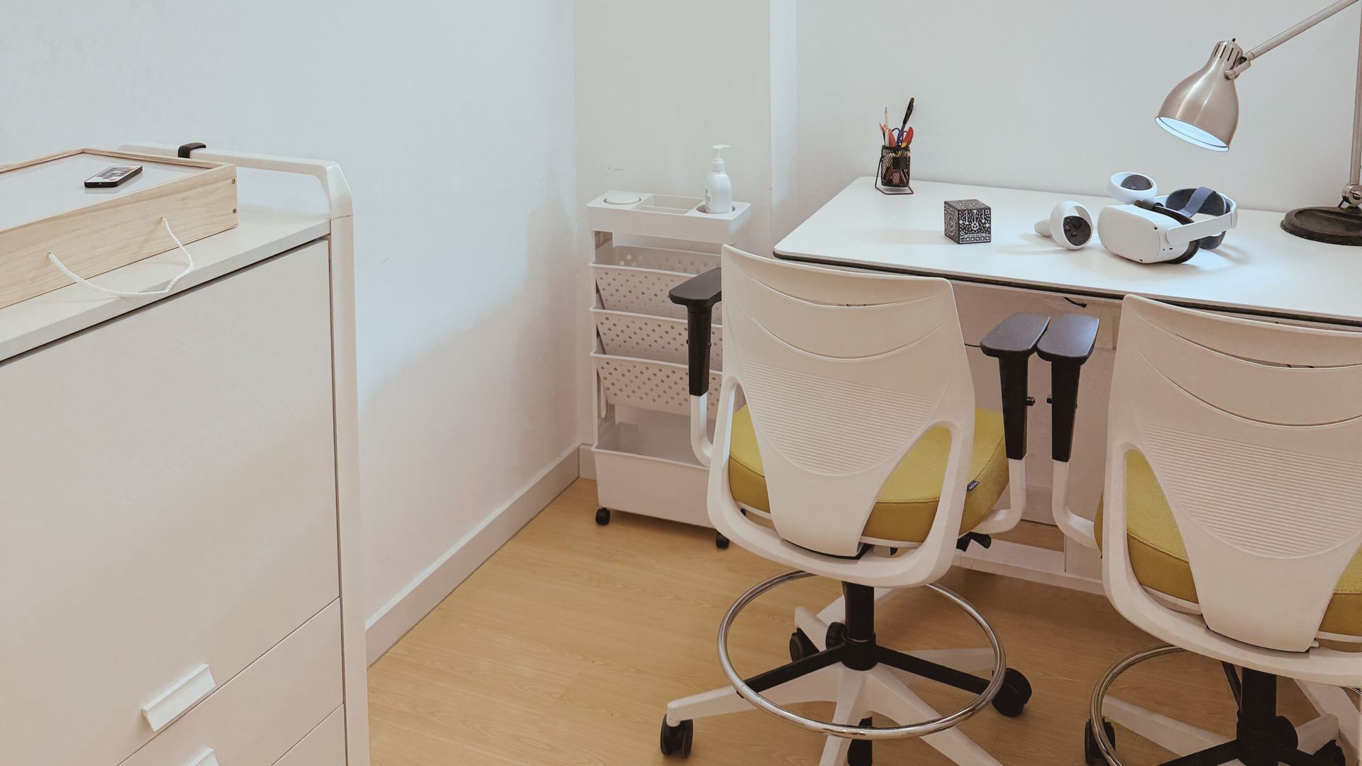 Una habitación con dos escritorios y sillas y una lámpara.