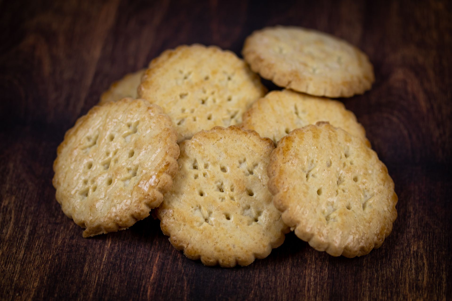 Biscuits ronds dorés sur une surface en bois.