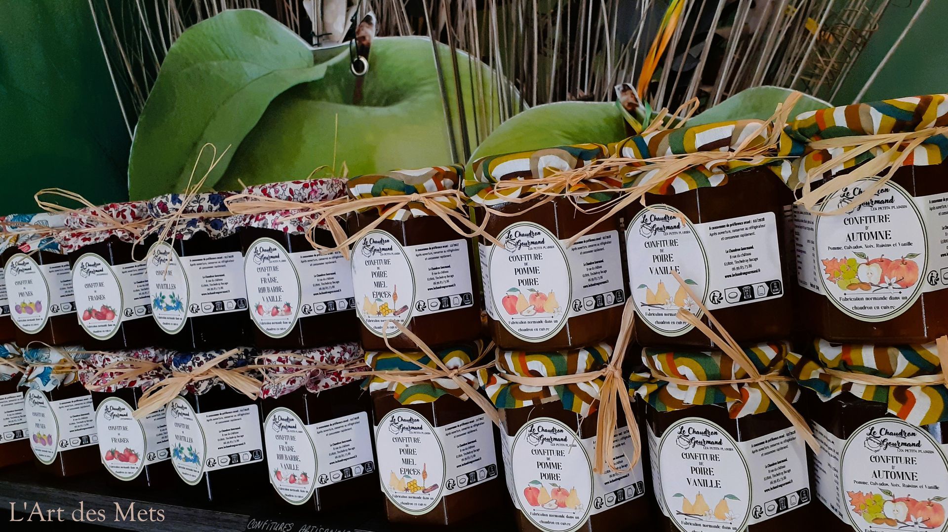 Des pots de confiture artisanale, étiquetés et disposés sur un présentoir.