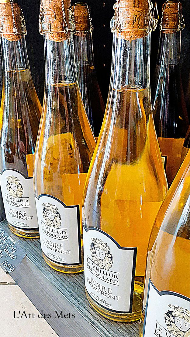 Des rangées de bouteilles de vin mousseux avec bouchons de liège et étiquettes.