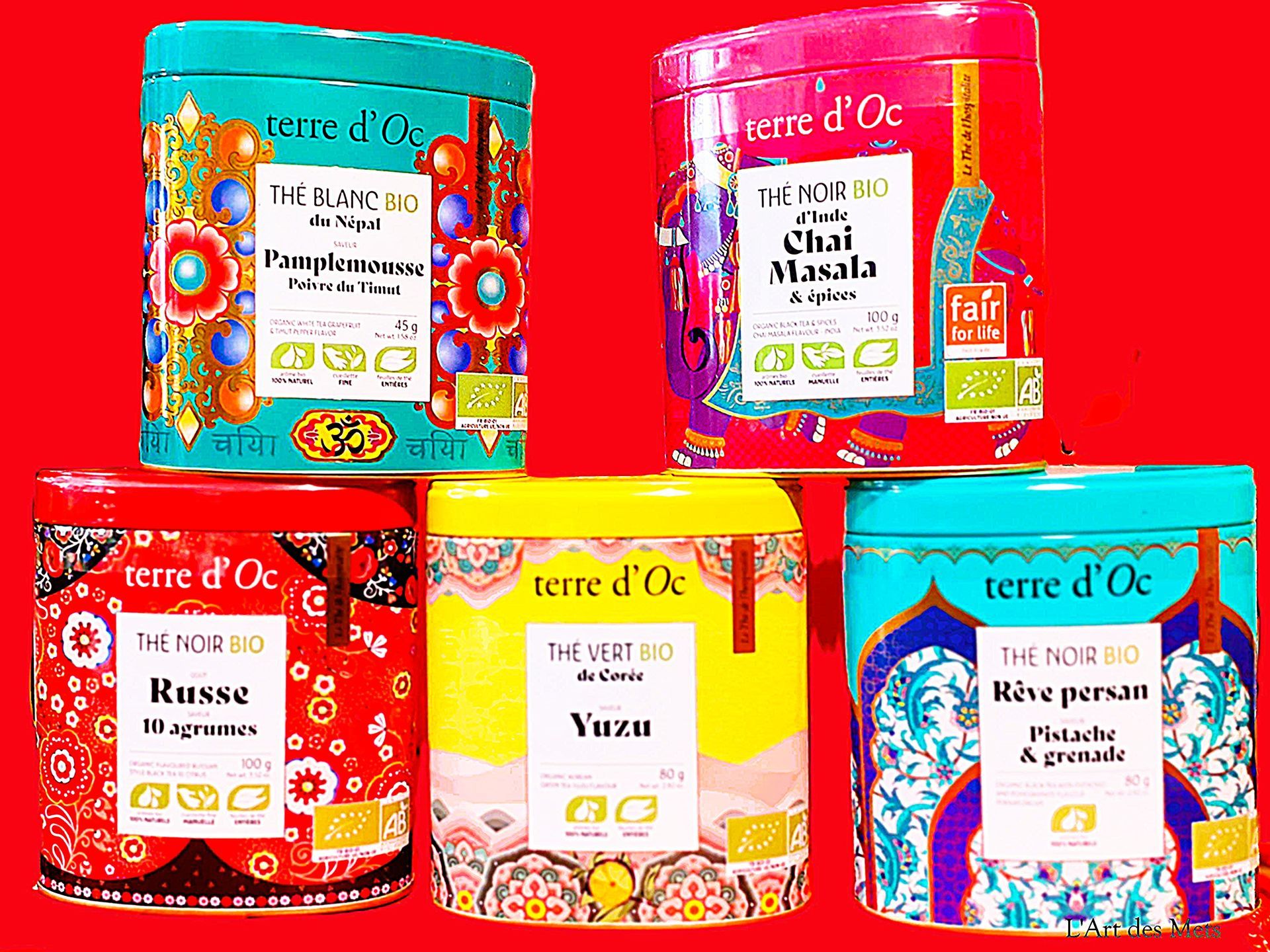 Cinq boîtes de thé Terre d'Oc colorées avec des étiquettes florales.