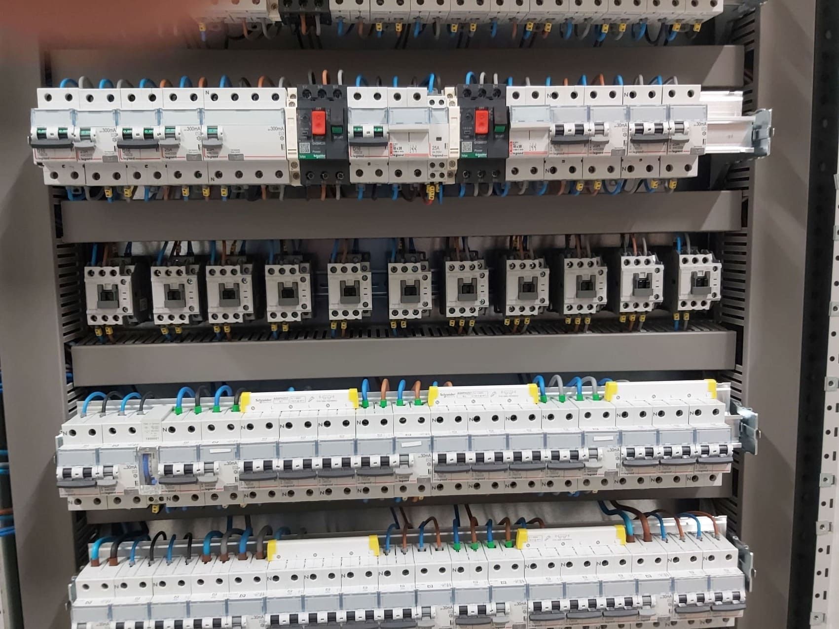 Un primer plano de un panel eléctrico con una gran cantidad de equipos eléctricos.