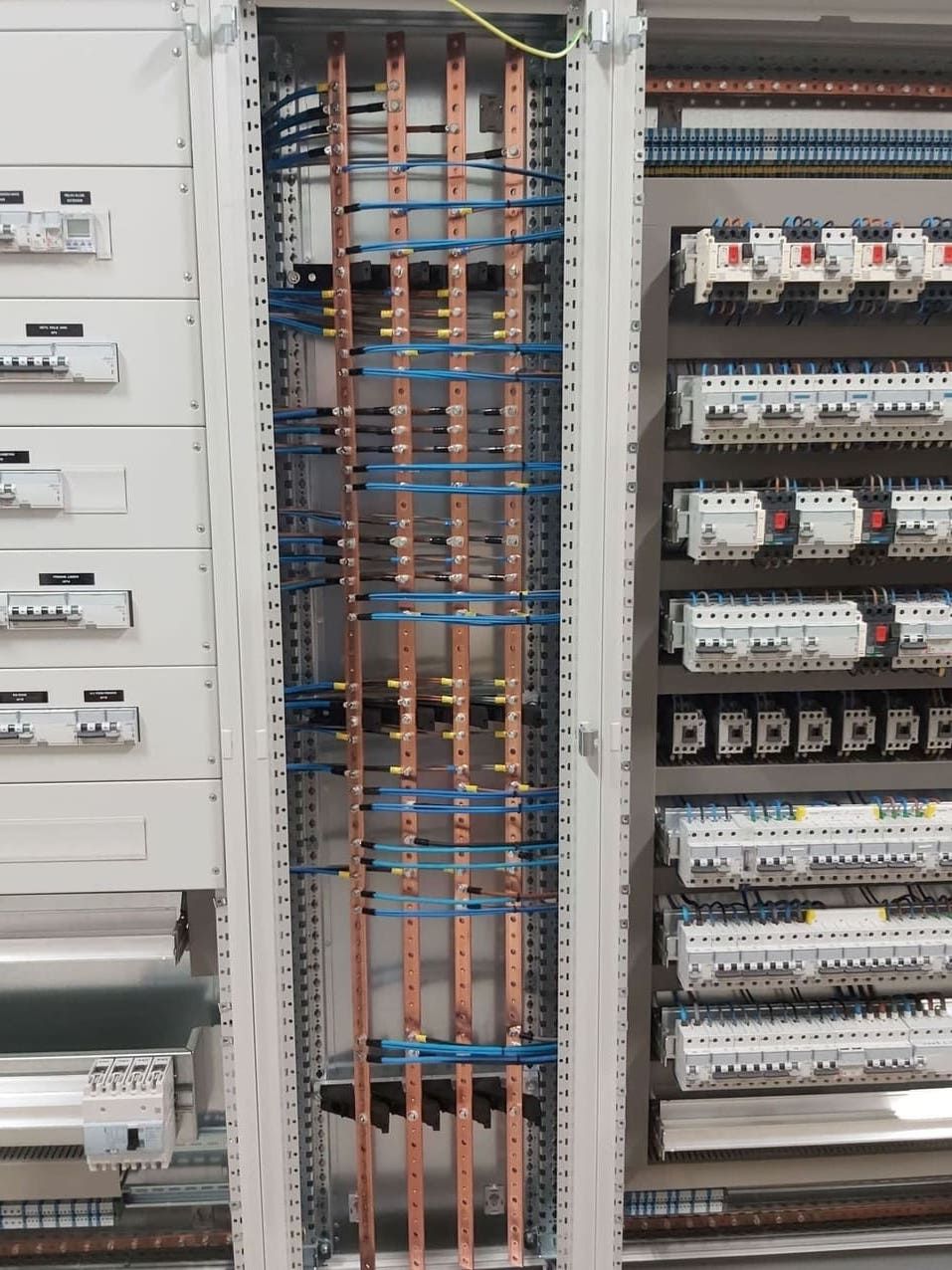 Un gran armario eléctrico del que salen cables de cobre.