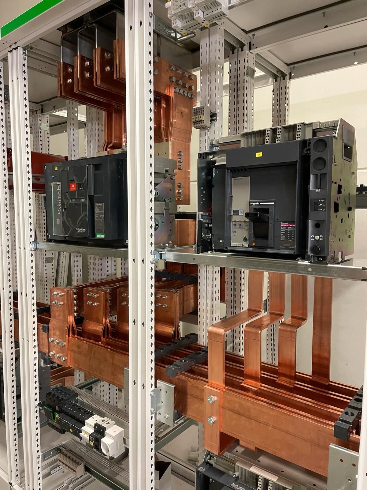 Un montón de equipos eléctricos están colocados en un estante en una habitación.