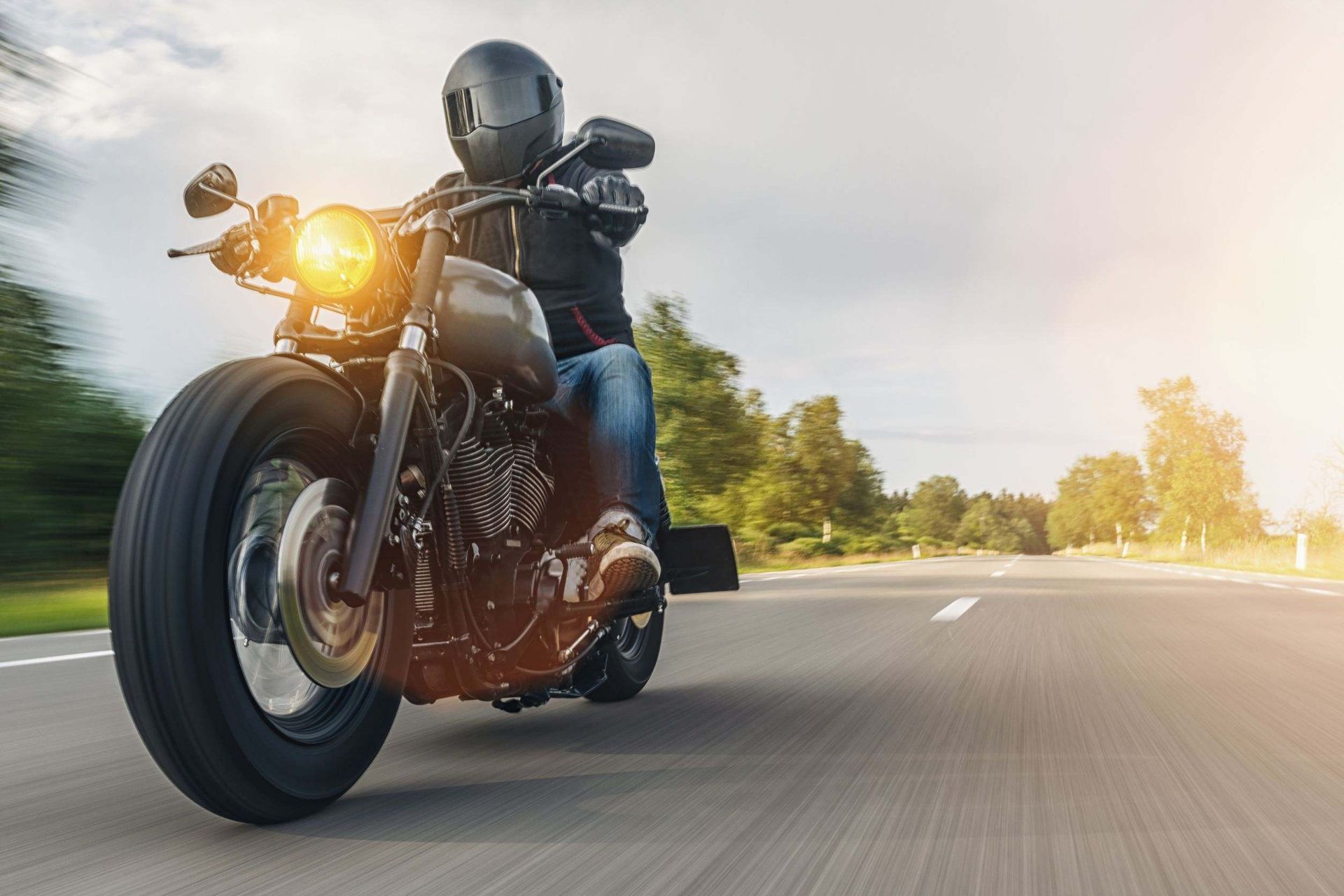 Un hombre va conduciendo una motocicleta por una carretera.