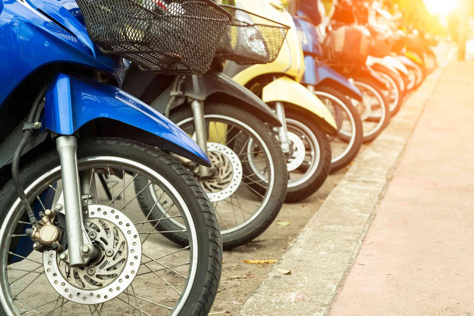 Una fila de motocicletas estacionadas al costado de la carretera.