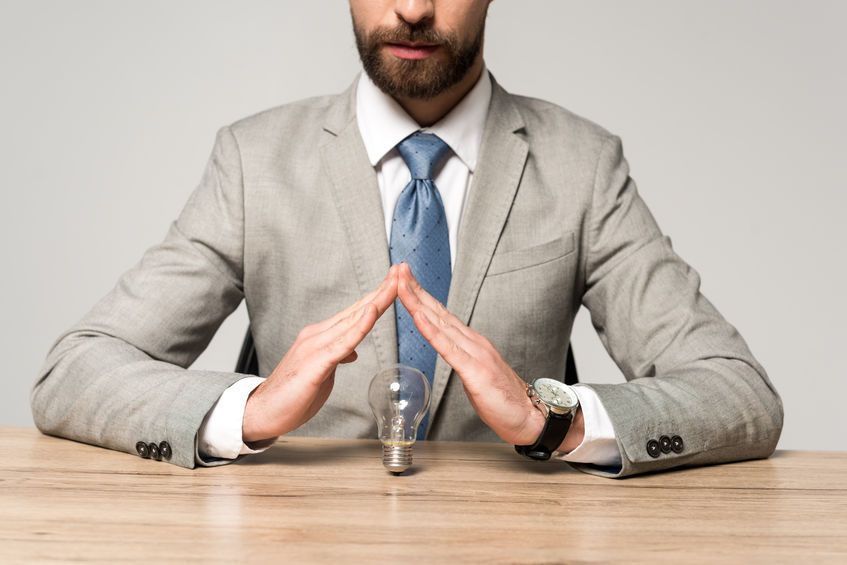 Una persona vestida con un traje gris y corbata azul 