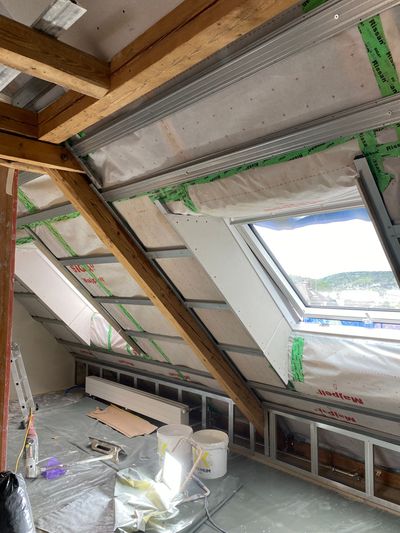 Kleines Badezimmer im Umbau mit weissen Wänden, einem Fenster und einem Dusch-/Badewannenbereich mit grünen Farbflecken.