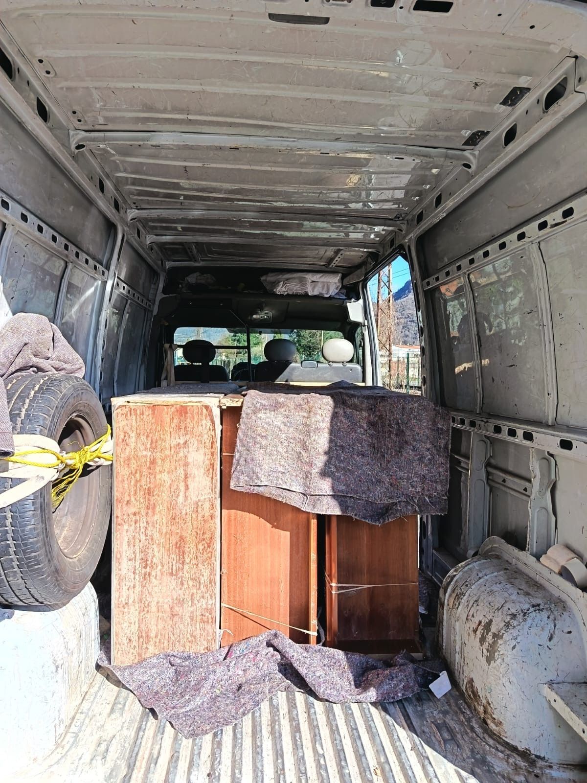 Des meubles protégés par des couvertures, chargés dans un camion.