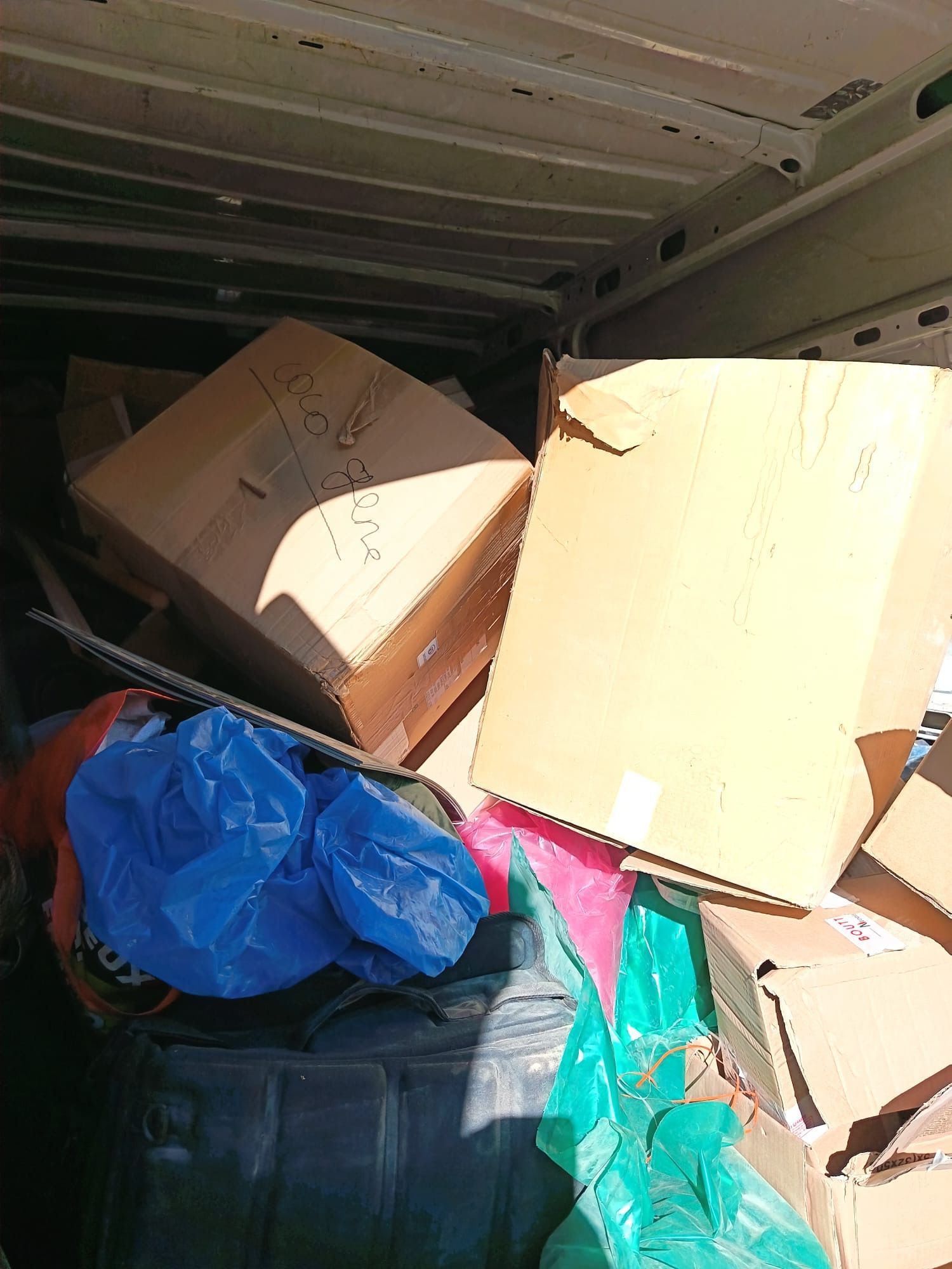 Des cartons et autres encombrants chargés dans un camion.