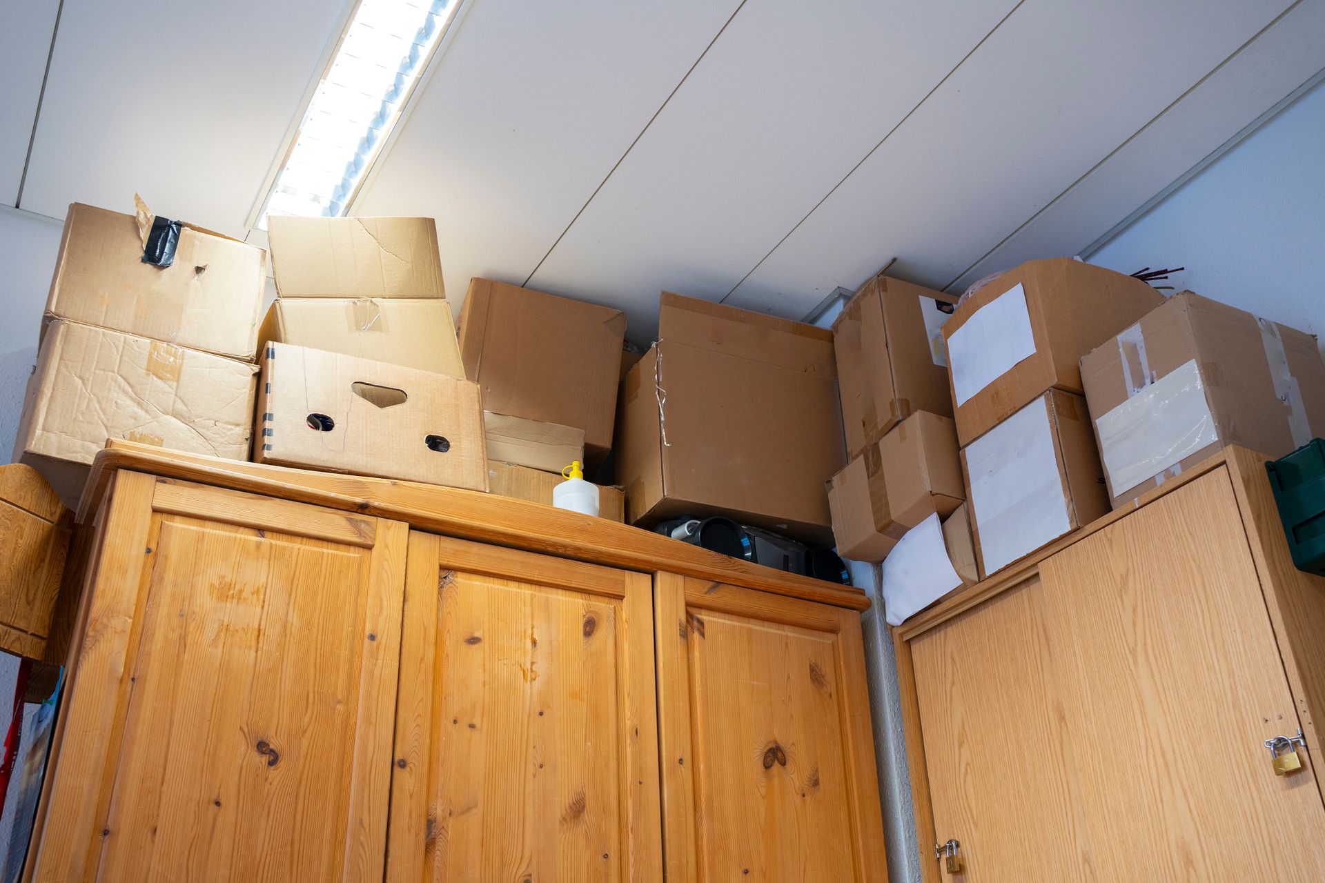 Des cartons posés au-dessus d'armoires dans un bureau.