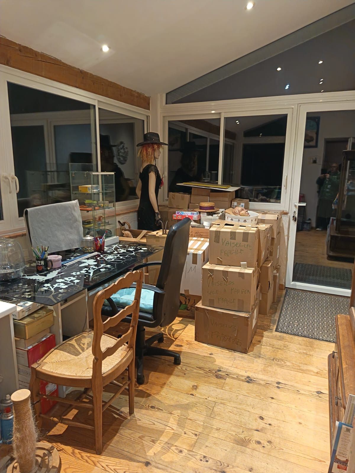 Des meubles et des cartons de déménagement entreposés dans une pièce.