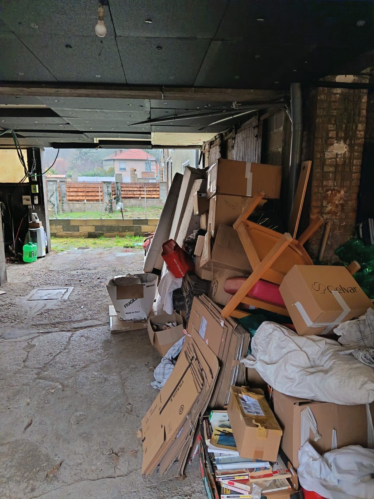 Une pile de cartons et d'objets encombrants rassemblés dans un garage.