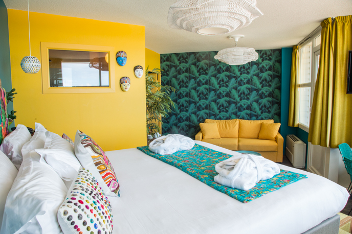 Une chambre d'hôtel avec un lit, un canapé et un miroir.