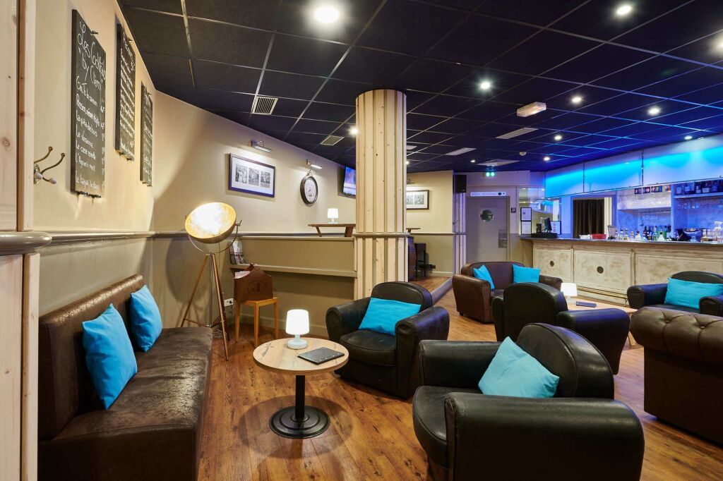 Un salon avec une table, des chaises et une lampe