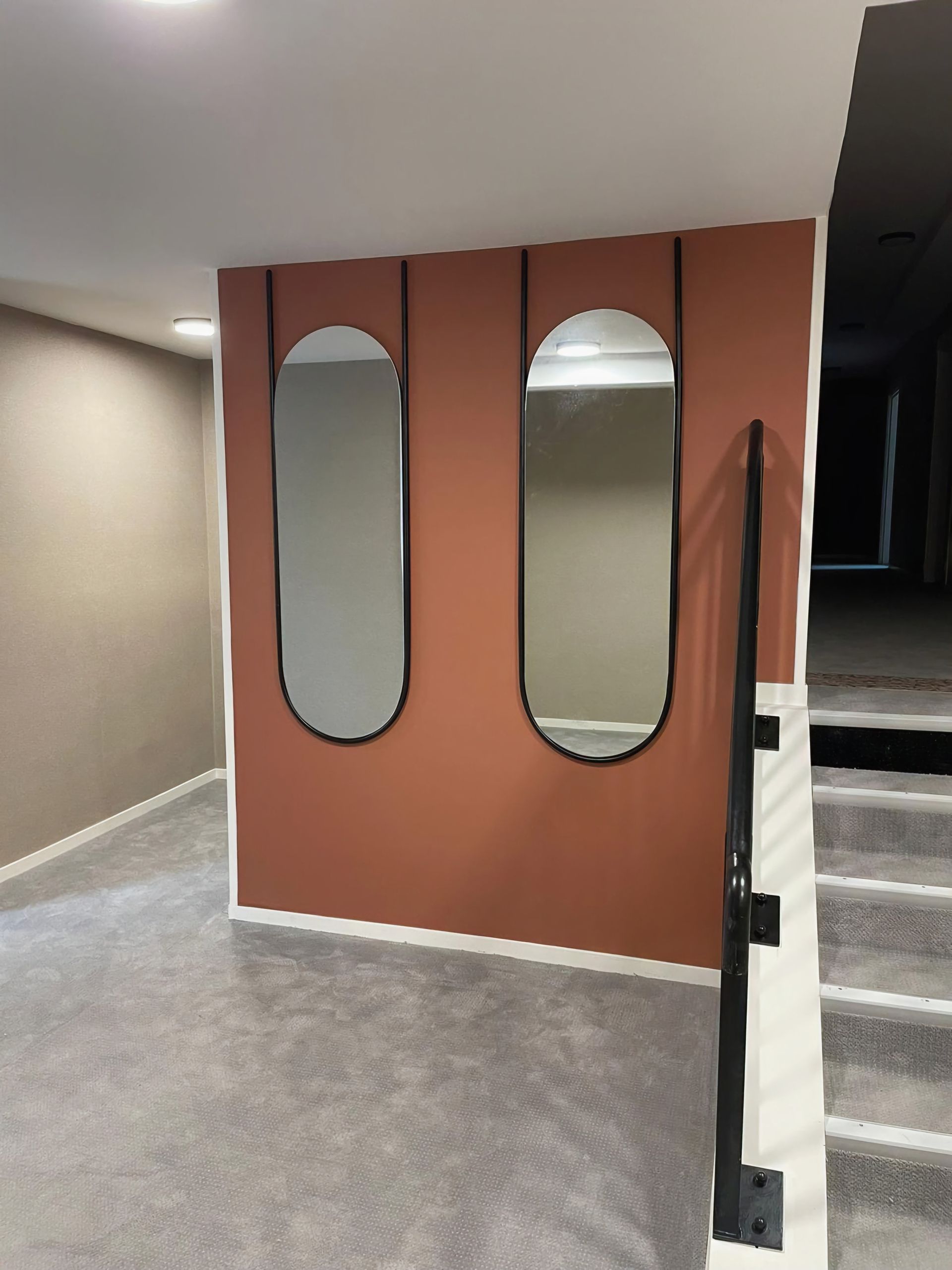 Une pièce avec deux miroirs sur le mur et des escaliers