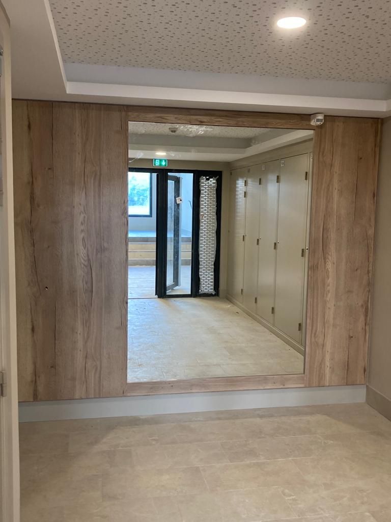 Un couloir avec des murs en bois et une porte vitrée