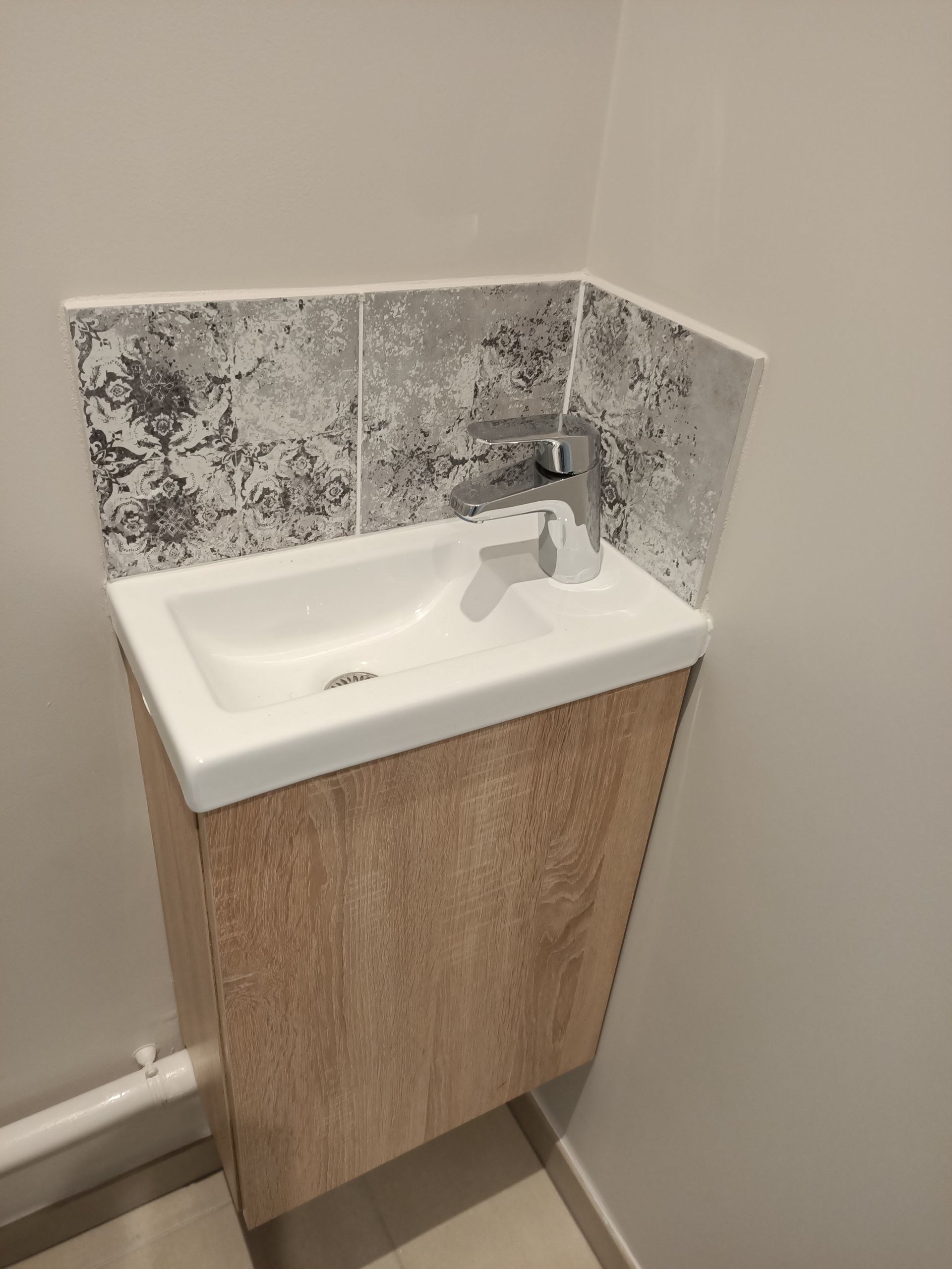 Un lavabo de salle de bain avec un meuble en bois en dessous.