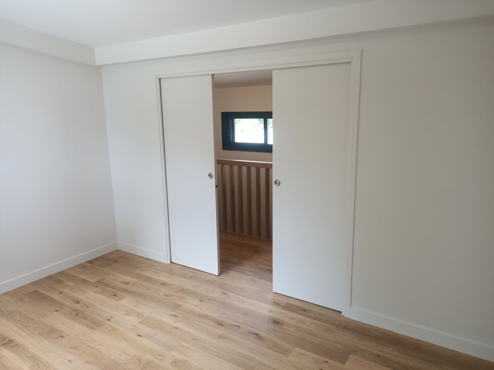 Une pièce avec deux chaises et un vase de fleurs