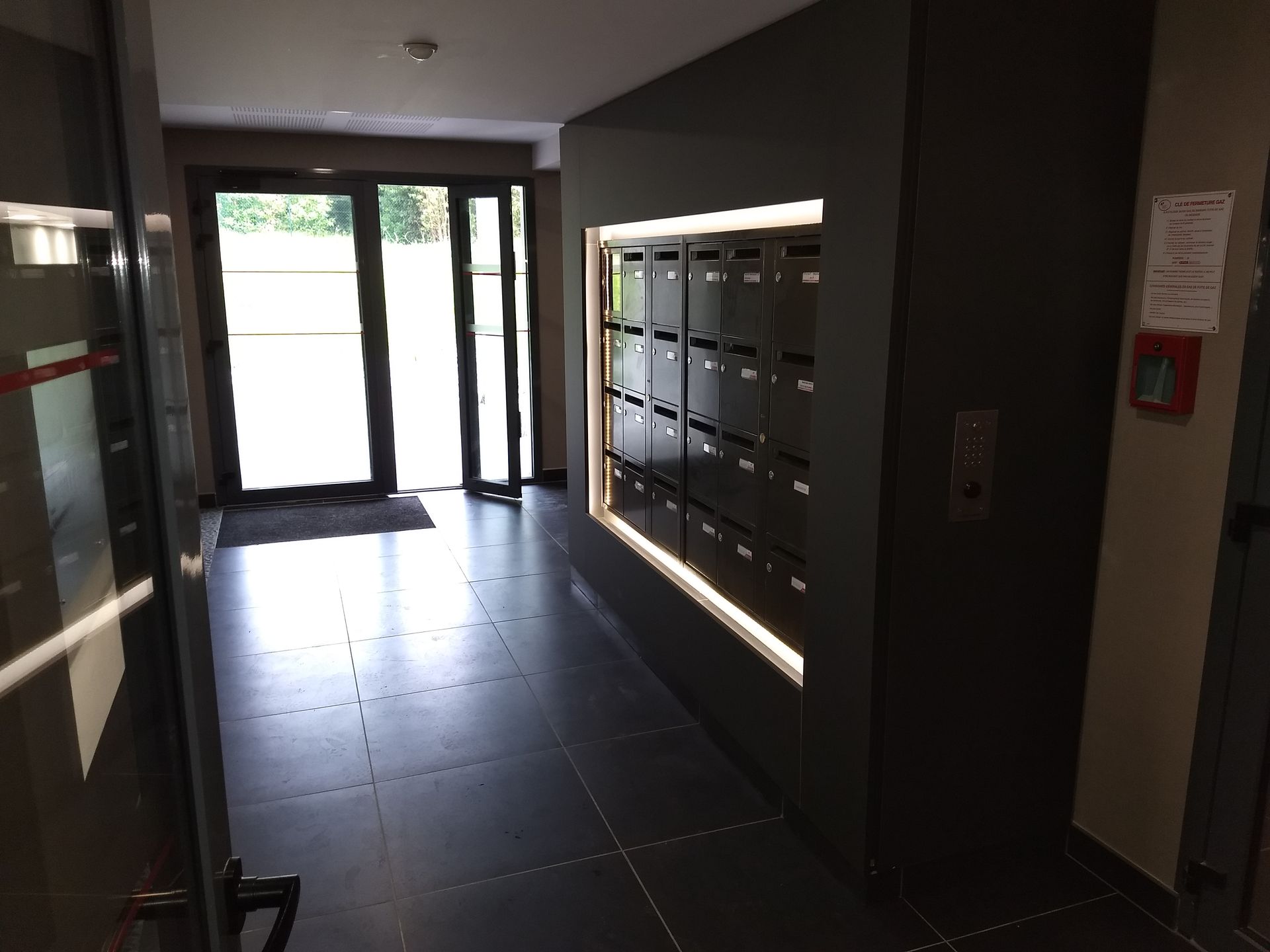 Un couloir avec beaucoup de boîtes aux lettres dedans